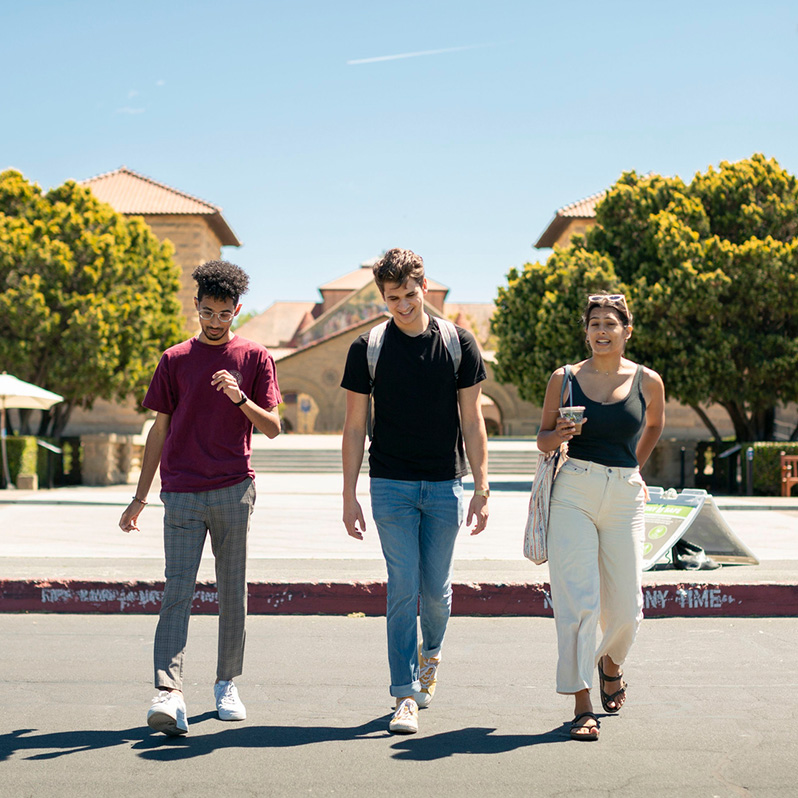 Three students walking together across campus